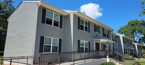 A grey house with black railings and windows.
