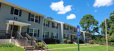 Apartment building with a blue sign in front.