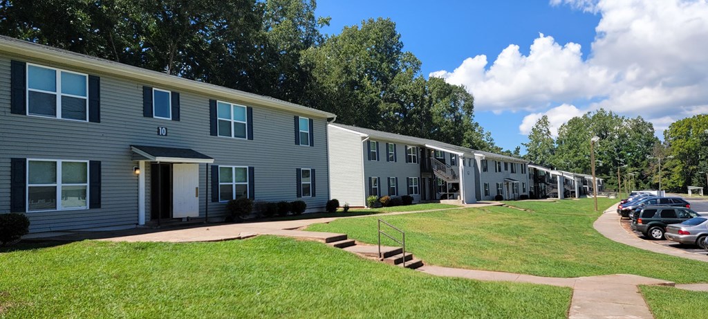a row of houses with cars parked in front of them