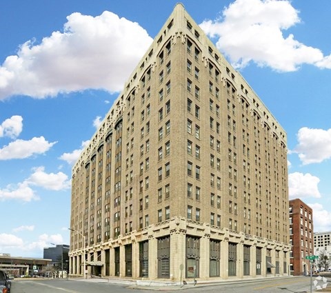 A large, beige, rectangular building with many windows and a flat roof.
