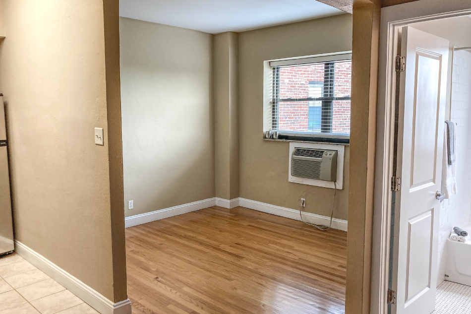 a living room with a window and wooden floors