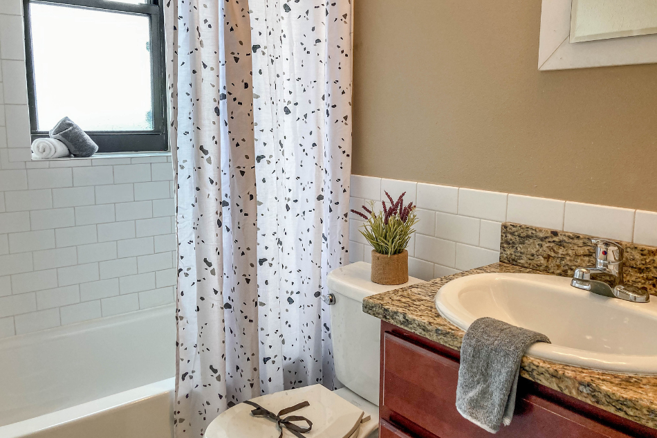 a bathroom with a sink and a tub and a shower curtain