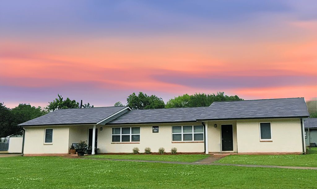 a white house with a sunset in the background