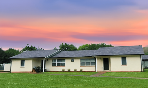 A house with a green lawn in front of it.