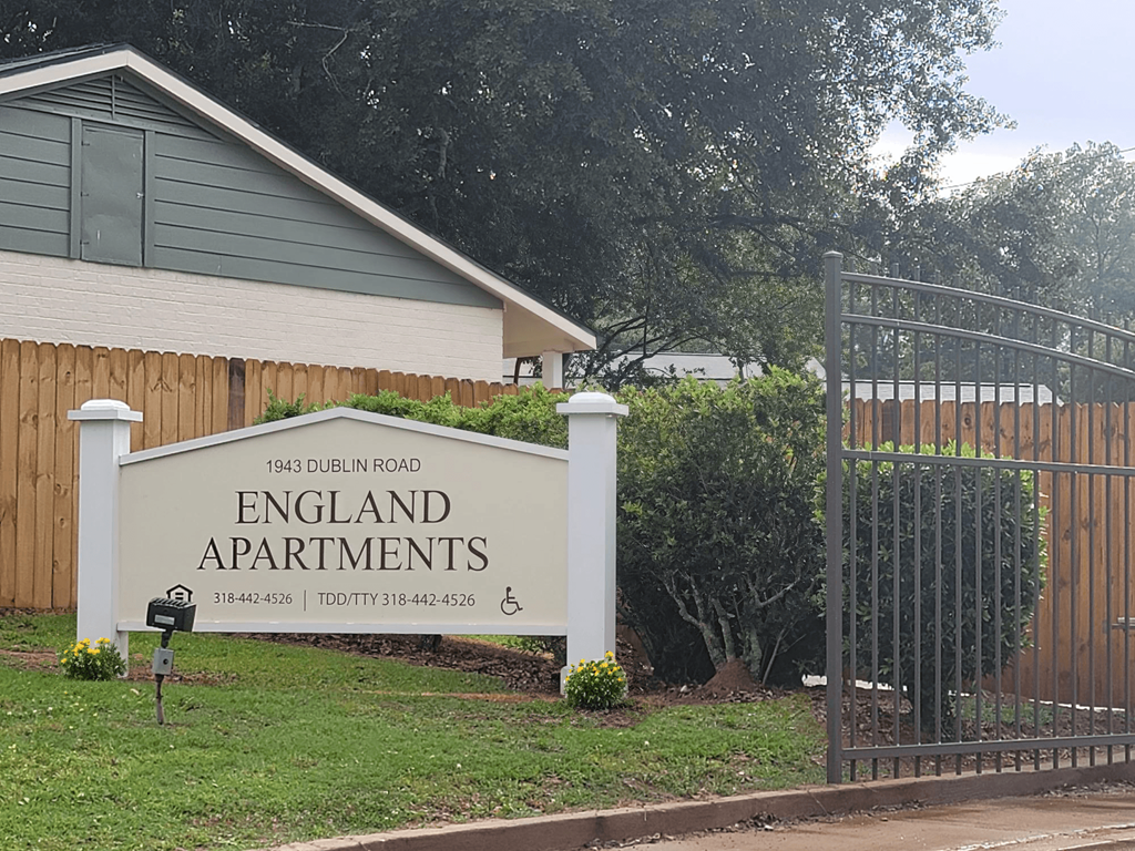 a sign for the apartments is shown in front of a gate