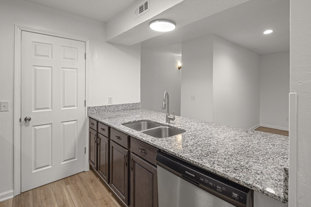 A kitchen with granite countertops and stainless steel appliances.