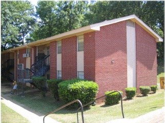 a small brick building with a staircase in front of it