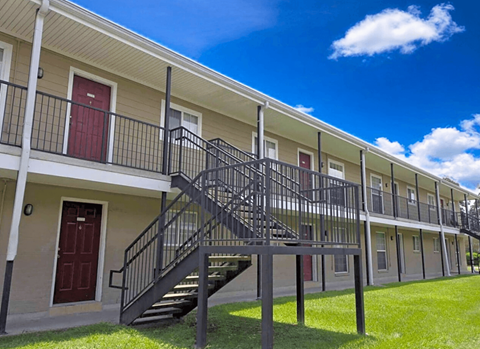 A building with a red door and a black metal staircase.