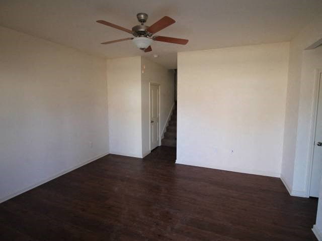 an empty living room with a ceiling fan