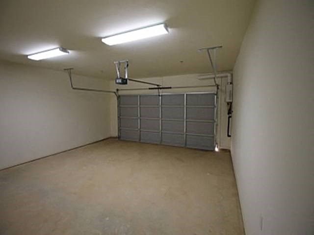an empty garage with a white wall and a garage door