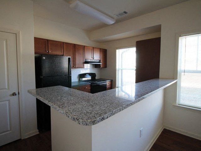 an empty kitchen with a granite counter top