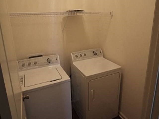 two washing machines in a small room with a door