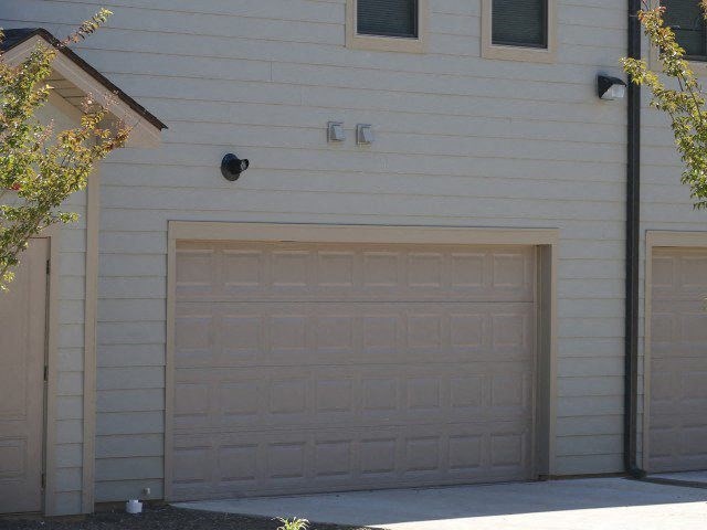 a garage door on the side of a white house