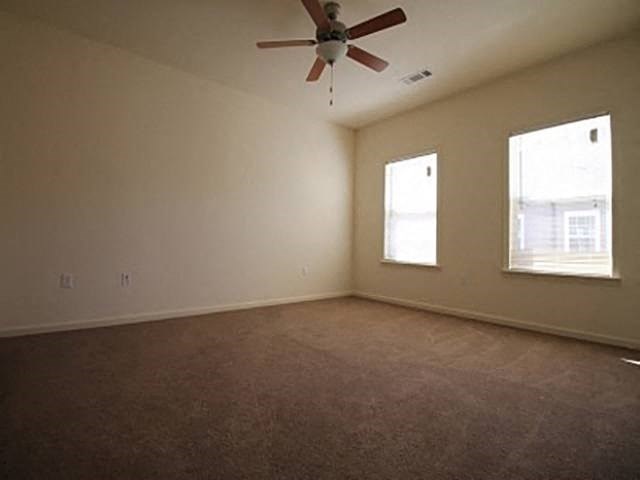 an empty living room with a ceiling fan