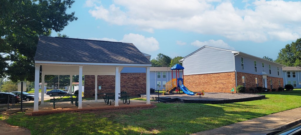 a house with a yard with a playground and a pavilion