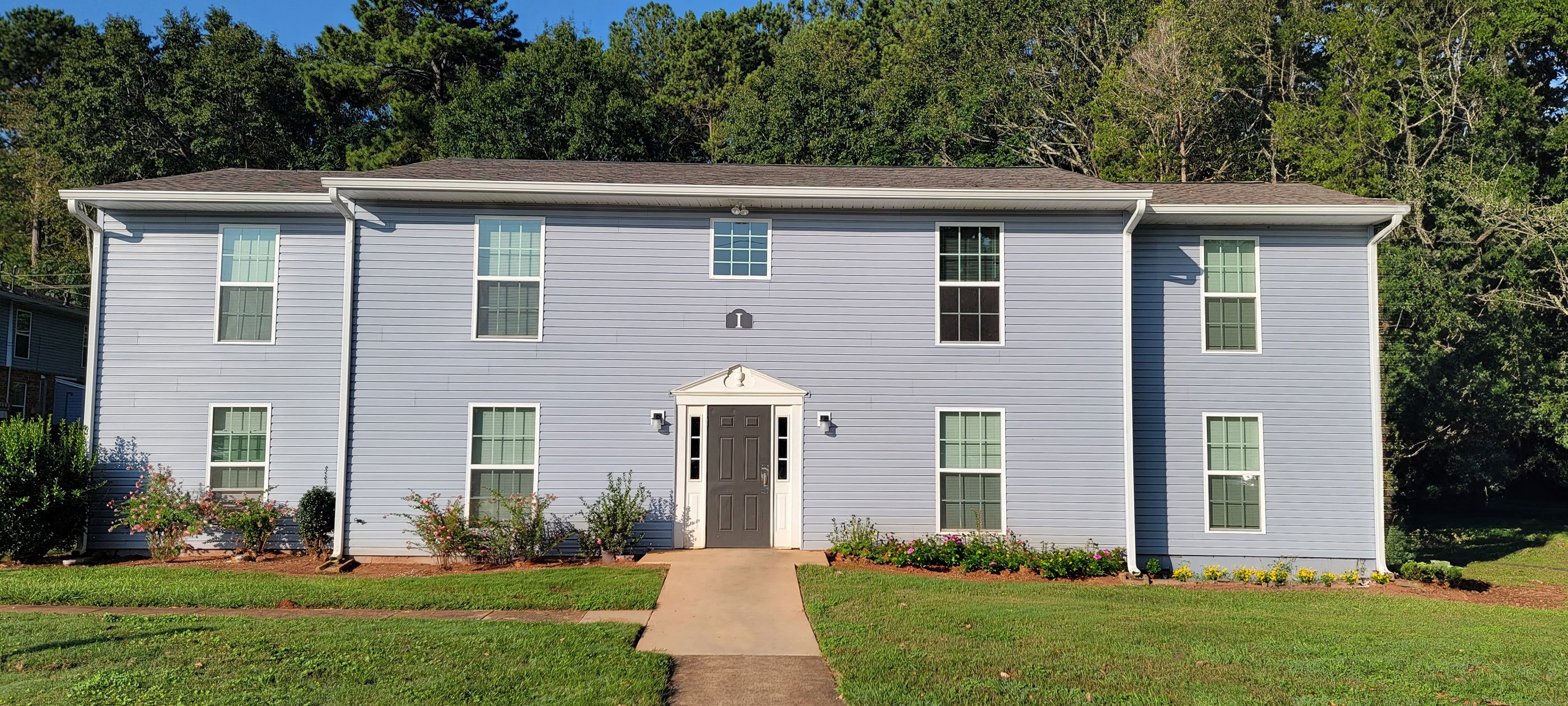 a white house with a sidewalk in front of it