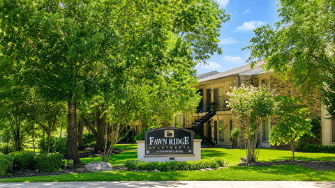 A sign that says "Fawne Ridge" in front of a house.