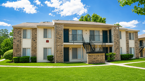 Apartment building with a green lawn in front.