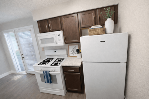 A white refrigerator stands in a kitchen with wooden cabinets and a white stove.