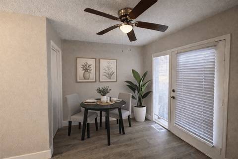 A dining room with a table, chairs, and a ceiling fan.
