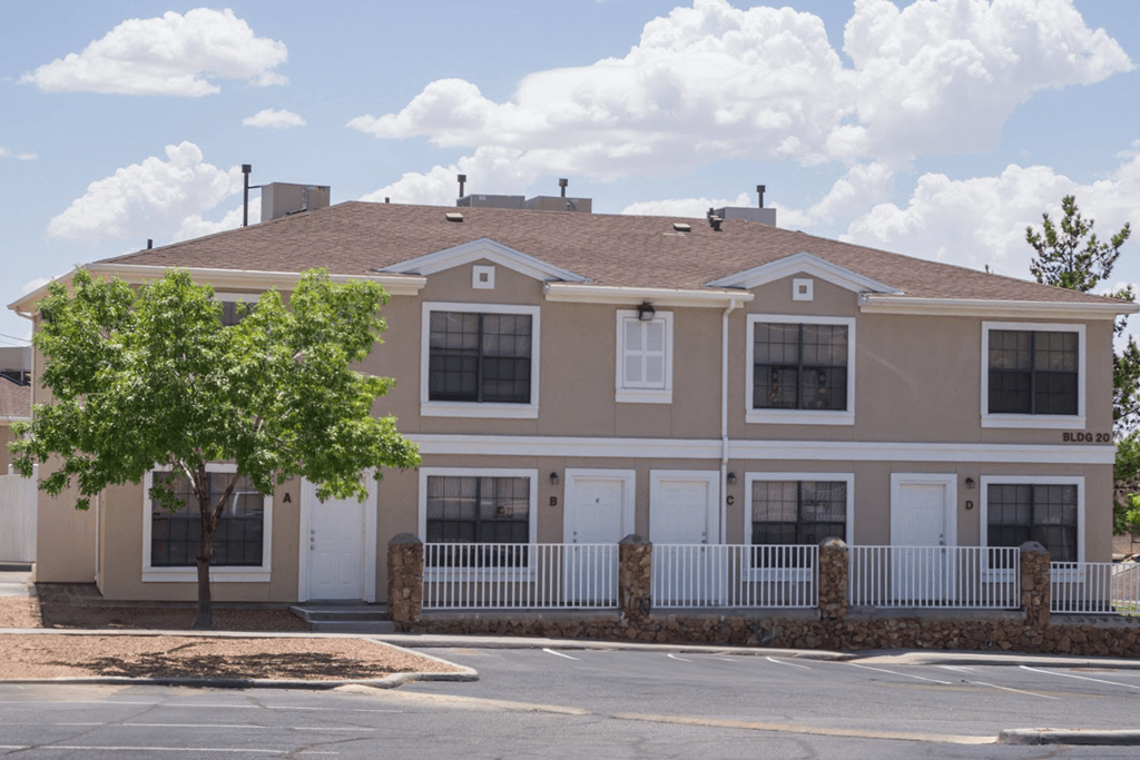 a large house with a tree in front of a street