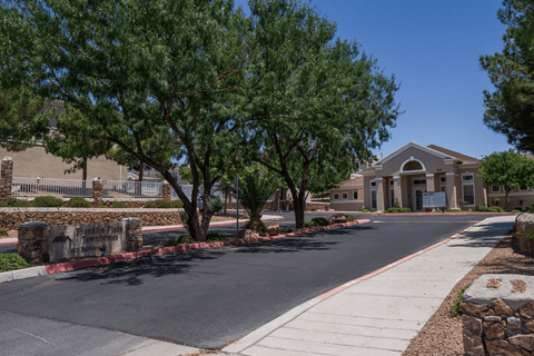 A street view of a residential area with a house and trees.