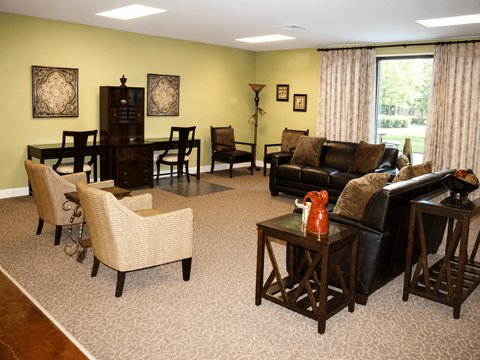 A living room with a black couch, a coffee table, and a dining table with chairs.