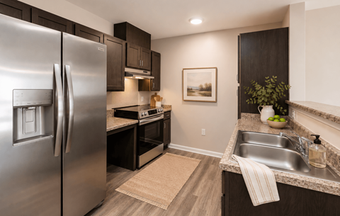 A modern kitchen with a stainless steel refrigerator and dark wood cabinets.