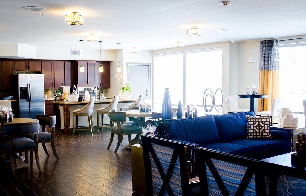 A living room with a blue couch and a dining table with chairs.