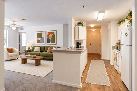 A kitchen with a refrigerator, sink, and a dining table with chairs.
