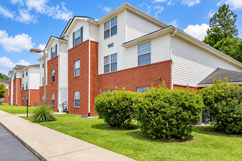 Apartment building with red brick and white siding.