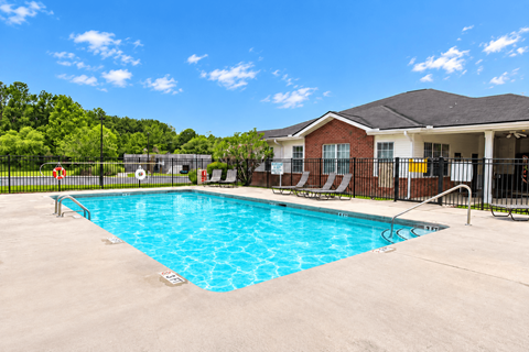 A swimming pool in front of a house.