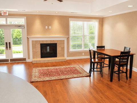 A living room with a fireplace and a dining table.