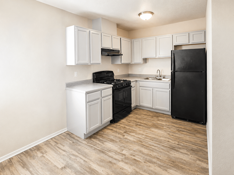 A kitchen with black appliances and white cabinets.