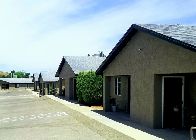 a row of small buildings with a parking lot