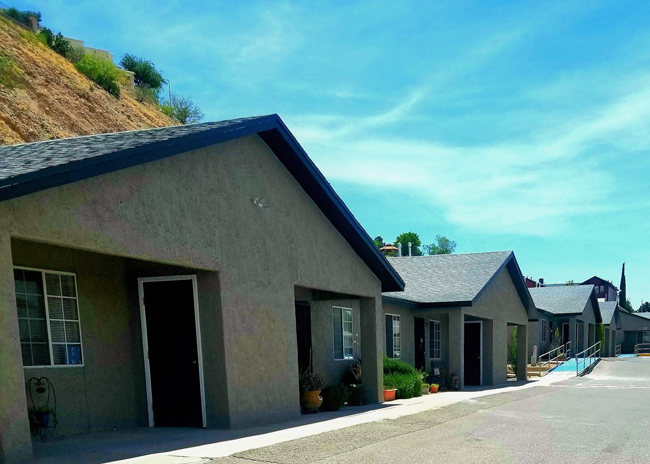 a building with a mountain in the background and a blue sky