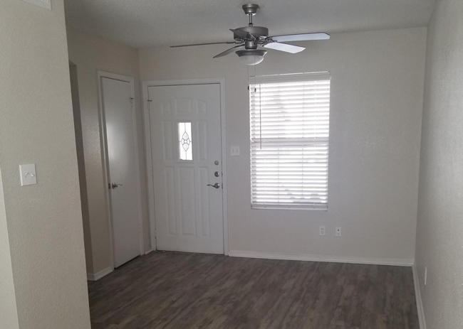 an empty room with a ceiling fan and a door
