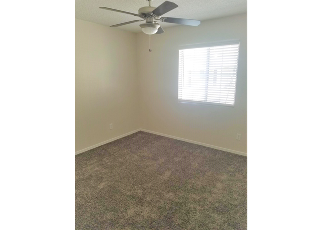 a bedroom with a ceiling fan and a window