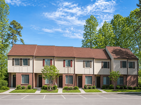 Apartment building with a parking lot in front.