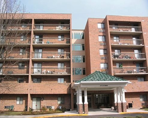 a large brick apartment building with a green roof
