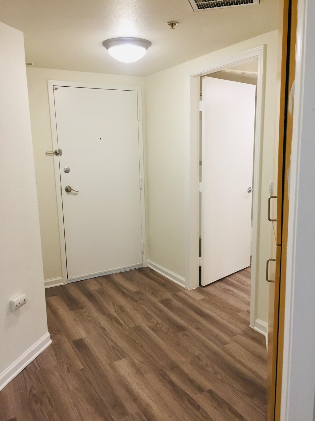 an empty room with a wood floor and white doors