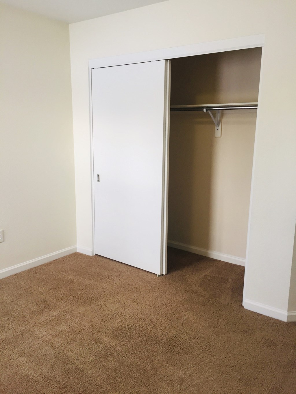 a room with a closet and a brown carpet