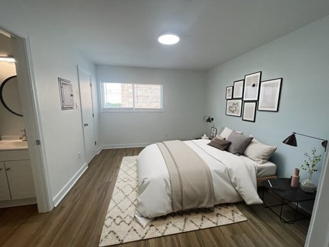 a bedroom with a bed and a bathroom in the background at The Courts Midtown, Memphis, TN, 38104