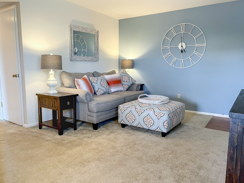 a living room with a couch and a clock on the wall