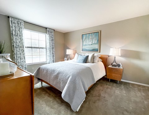 Master bedroom with neutral decor and blue accents at Richardson Place Apartments, Arnold, MO 63010