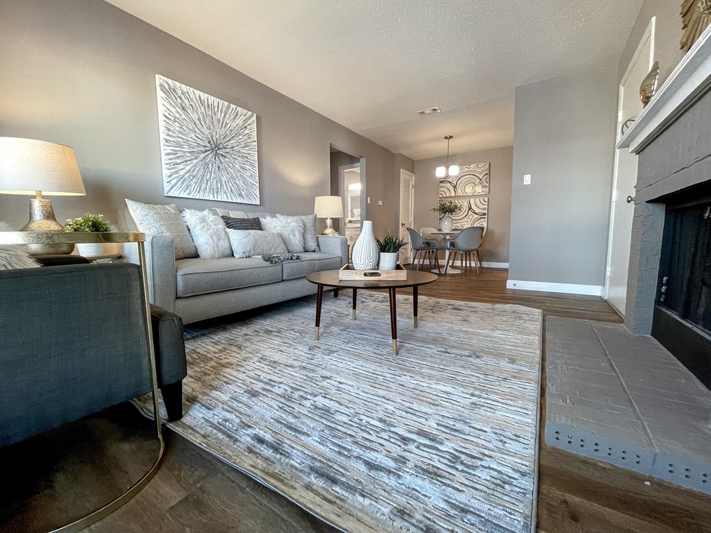 an open living room with a fireplace and a rug