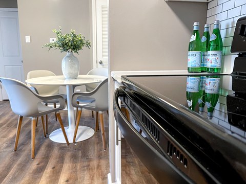 a kitchen with a table and chairs next to a stove and a refrigerator