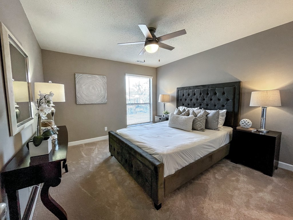 a bedroom with a large bed and a ceiling fan