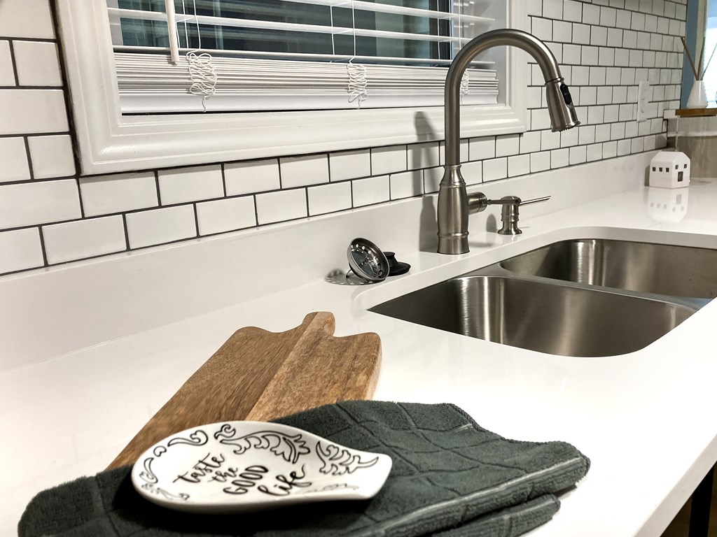 a kitchen counter with a sink and a towel on a cutting board
