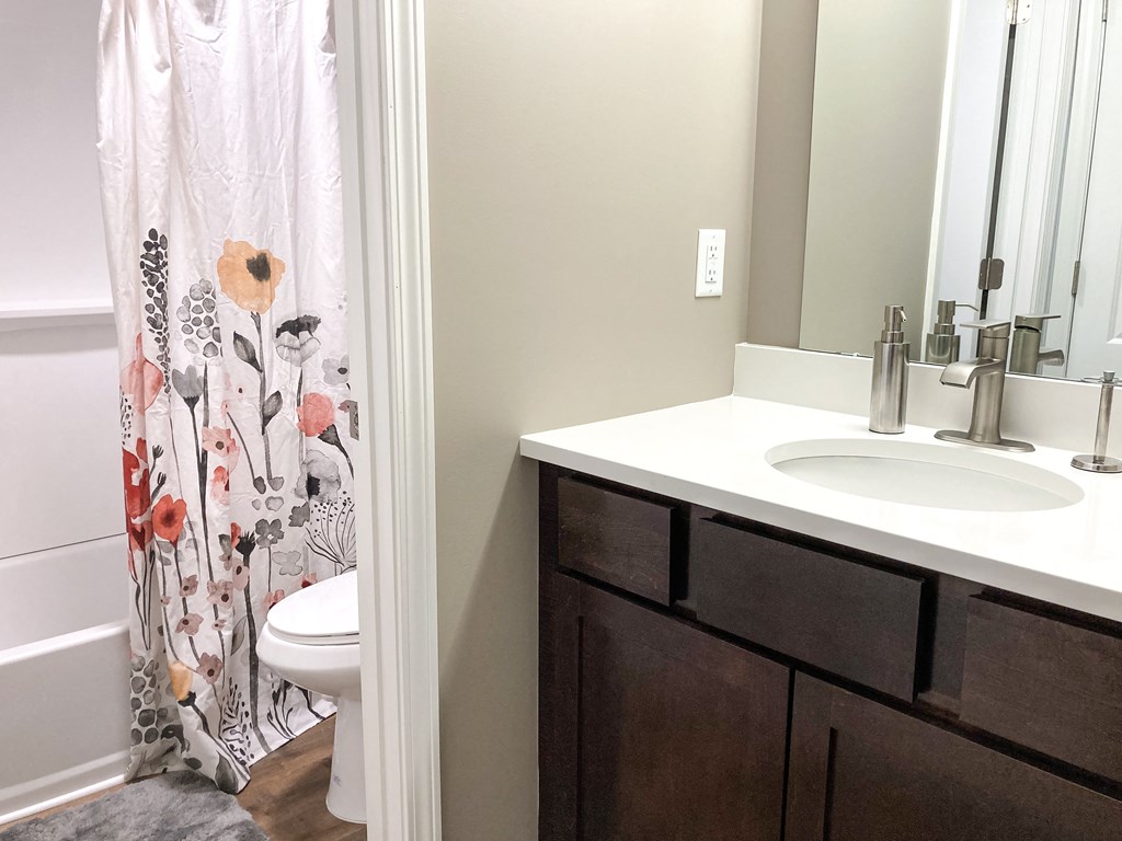 a bathroom with a sink and toilet and a shower with a shower curtain